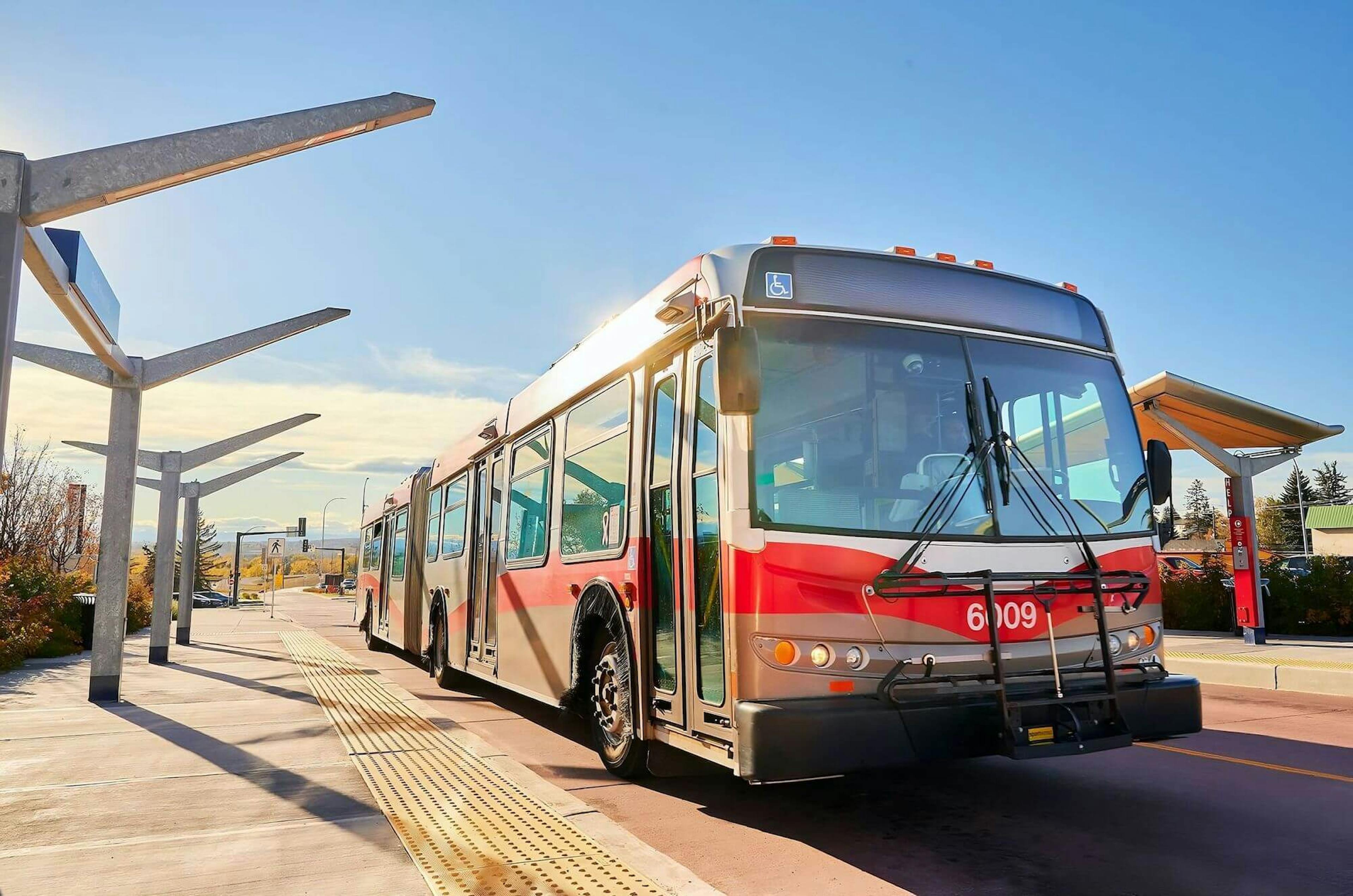 Double-length Calgary Transit bus, parked at a transit station.