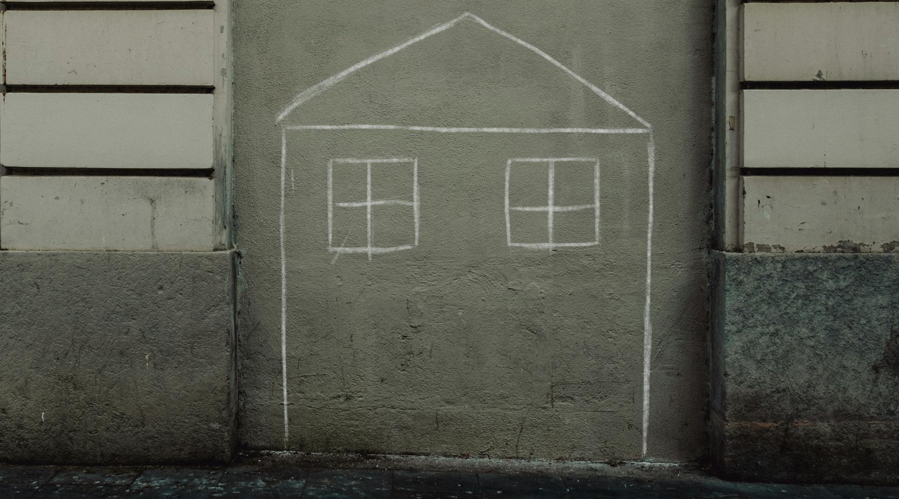 Chalk outline of a house drawn on a concrete wall