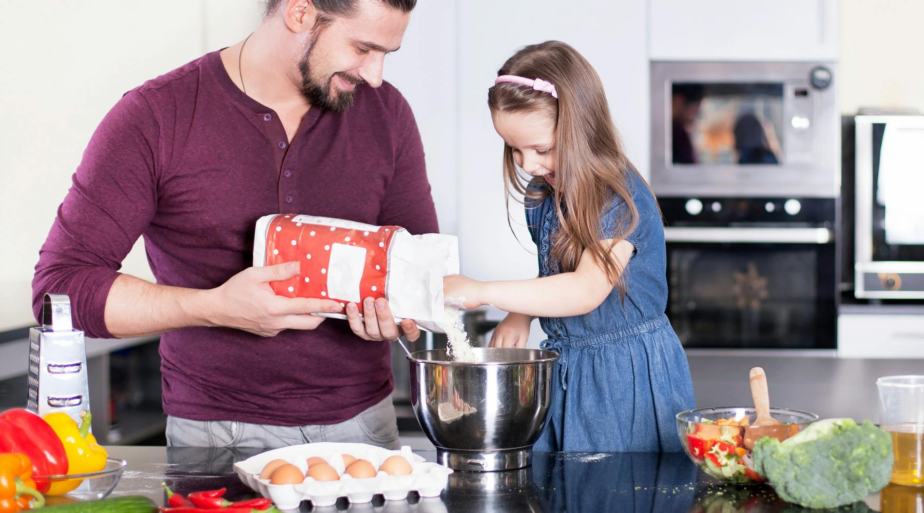 Child and parent cooking in a kitchen