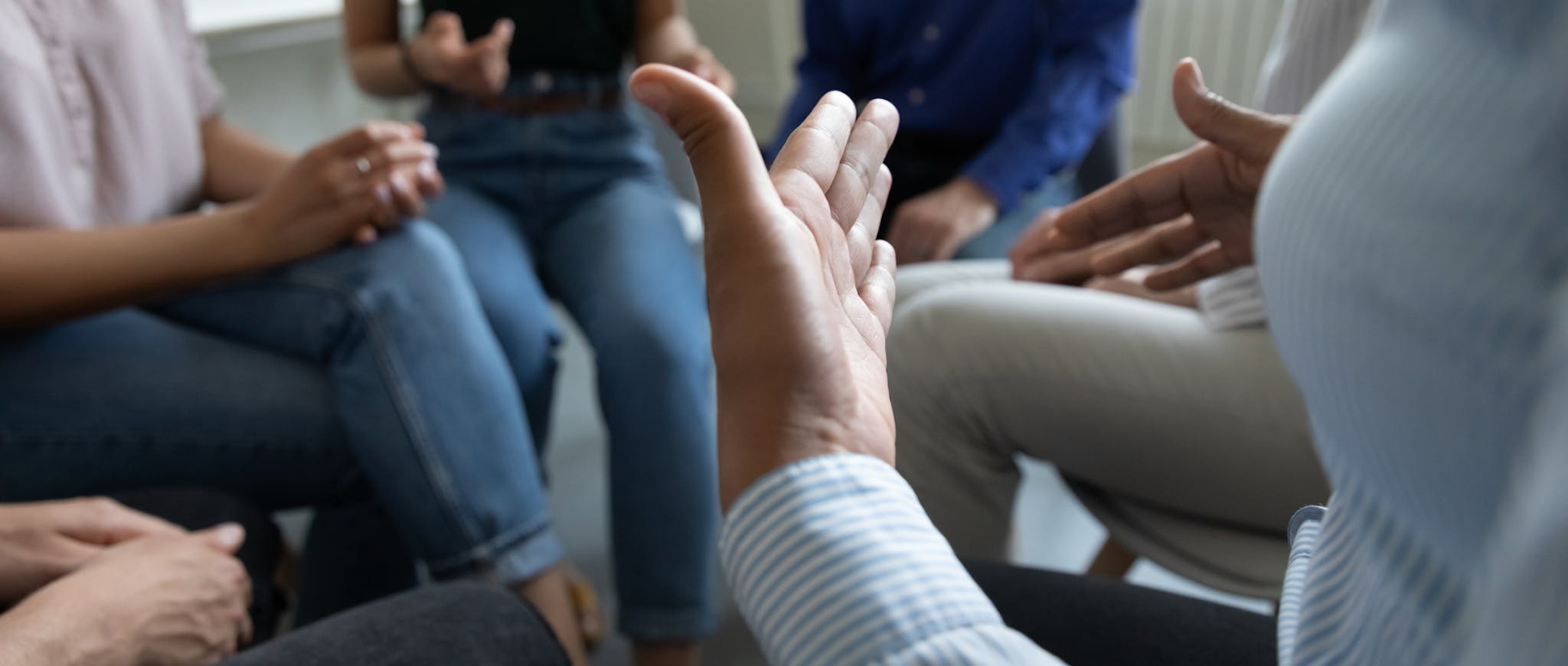A group of people meeting. The picture focus is on their hands.