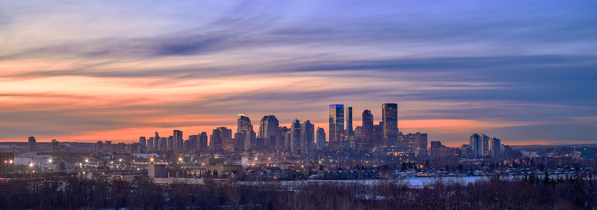 Wide view of the Calgary skyline at sunset.