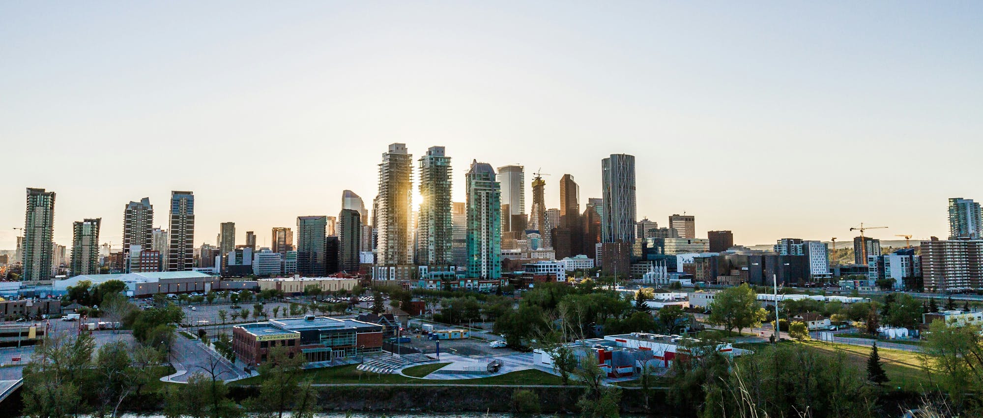 Wide-angle photo of the Calgary skyline with evening light reflecting off the towers.