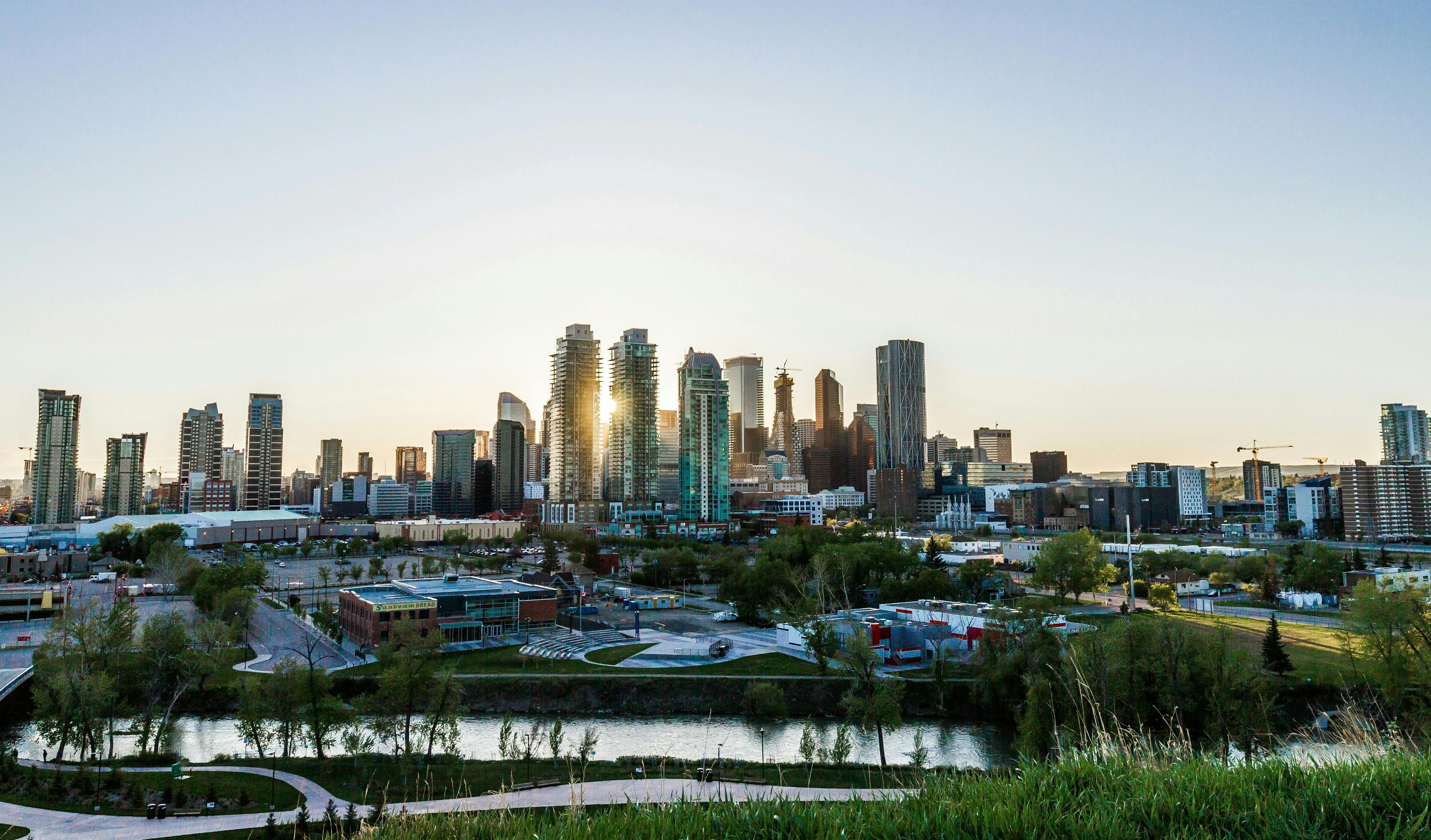 Wide-angle photo of the Calgary skyline with evening light reflecting off the towers.