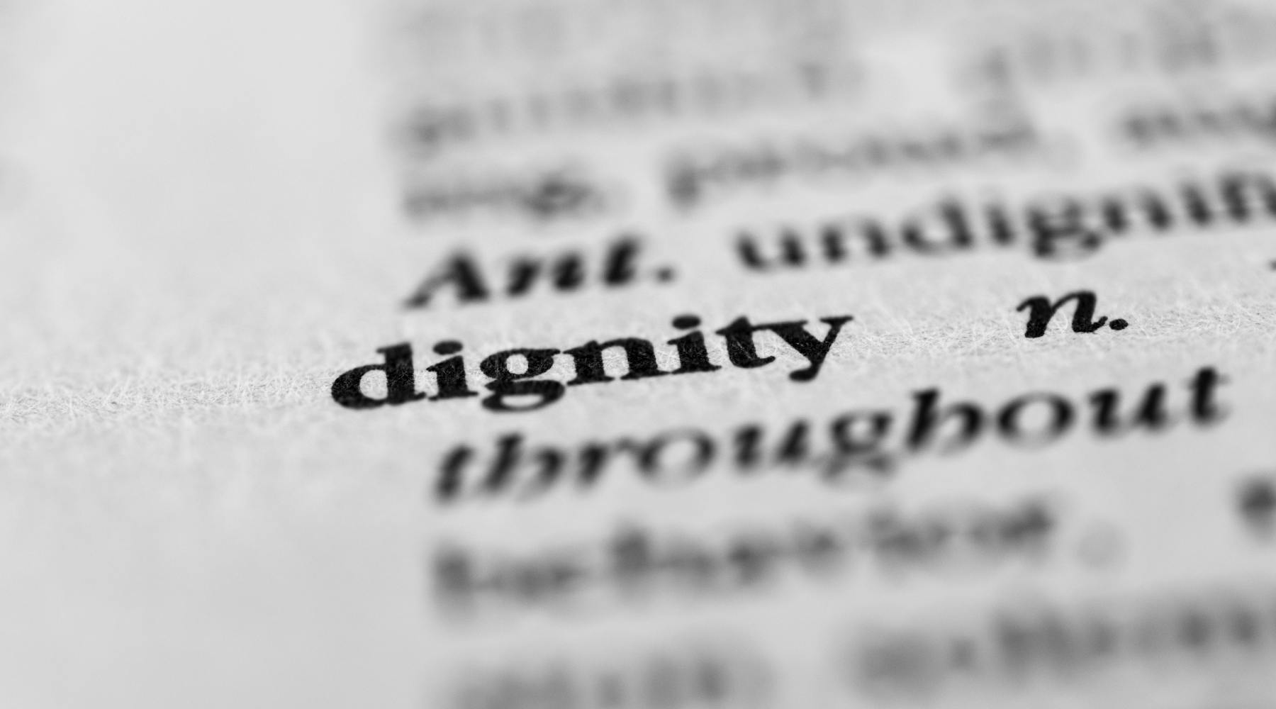 A dictionary page with the definition of dignity in focus