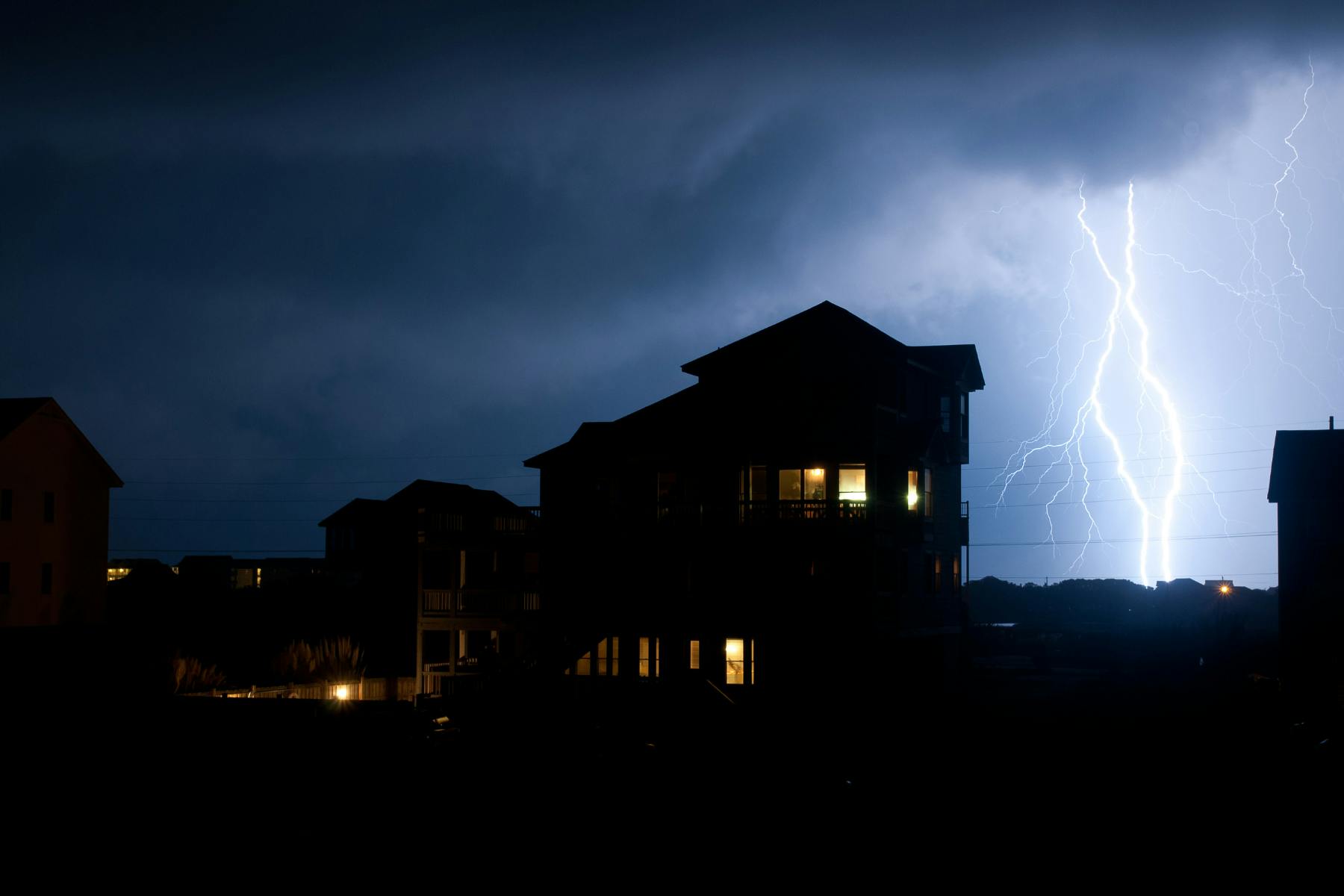 House at night with lightening in the background