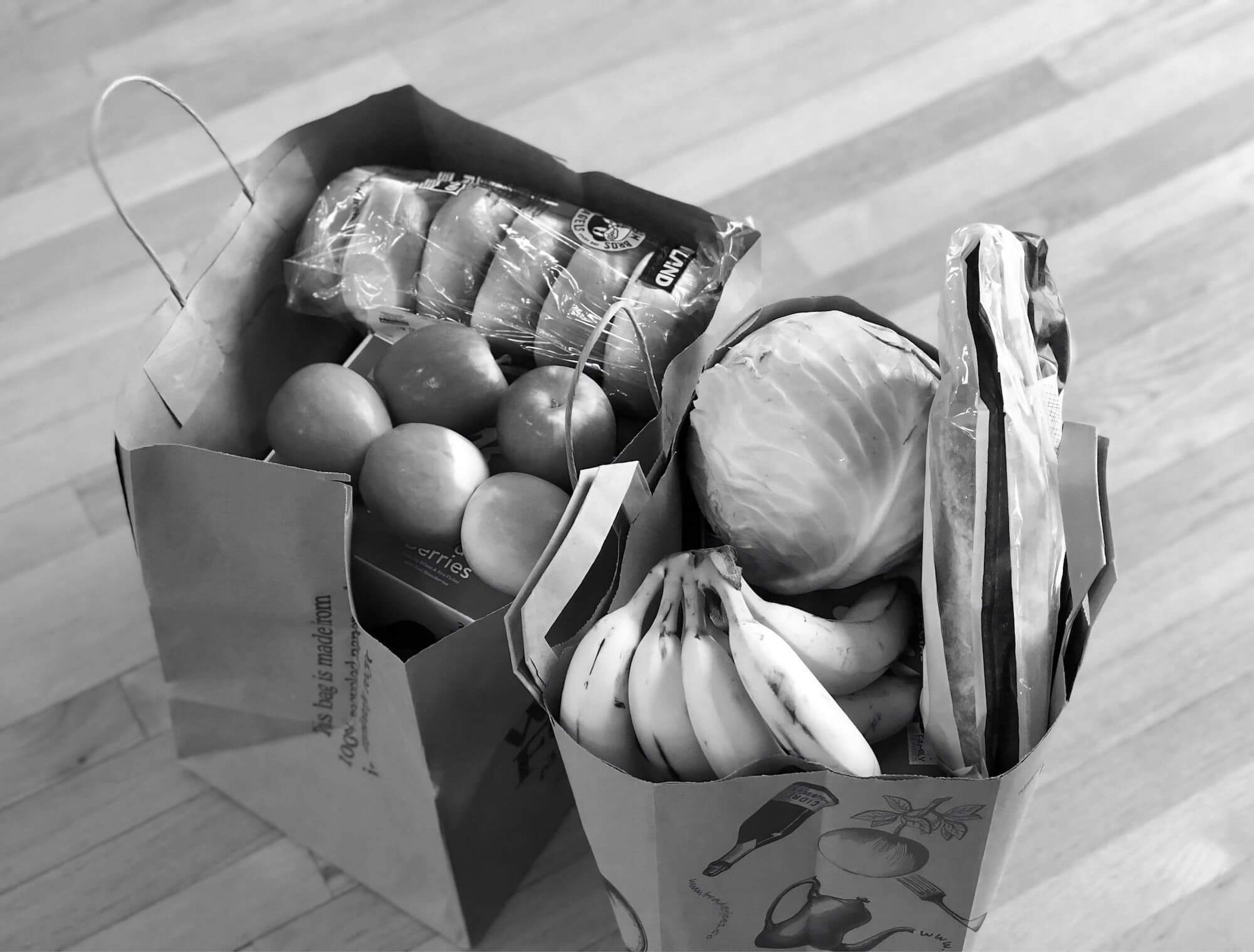 Two bags of fresh groceries, in black and white