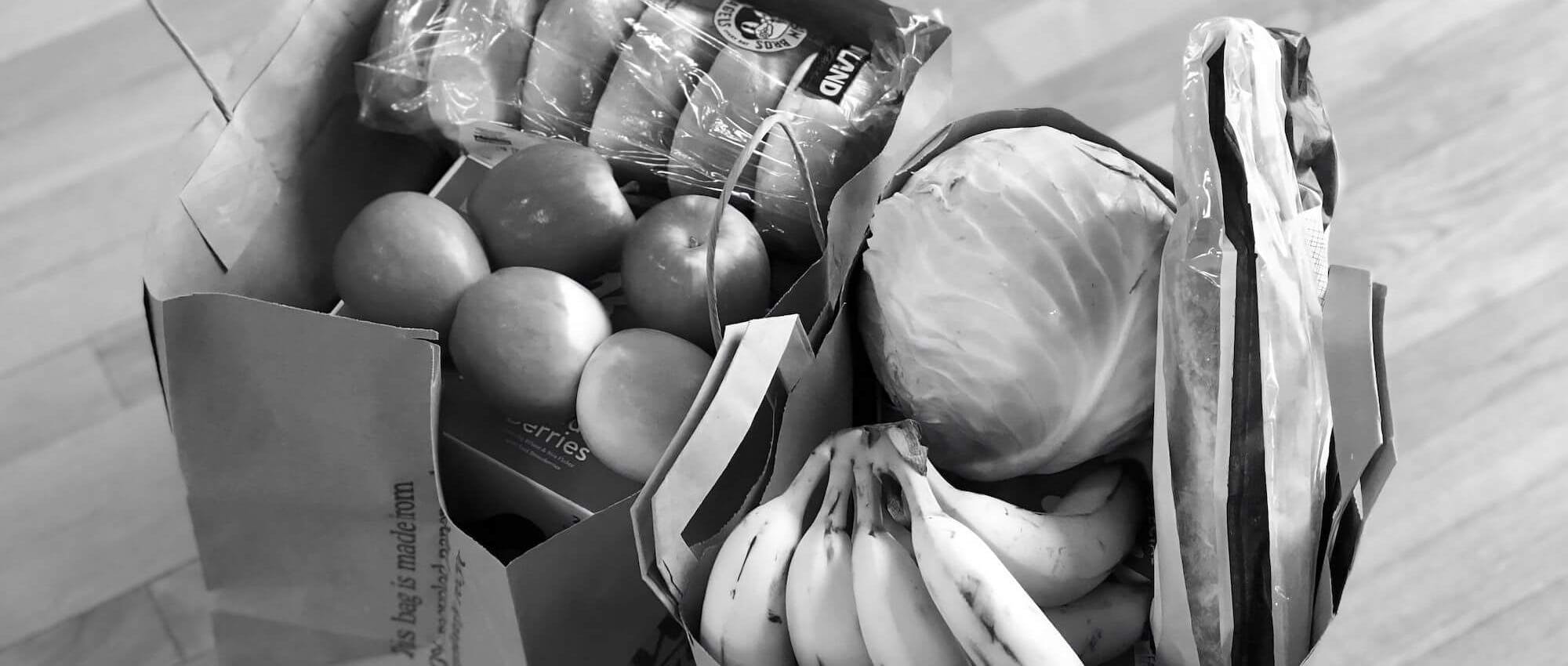 Two bags of fresh groceries, in black and white
