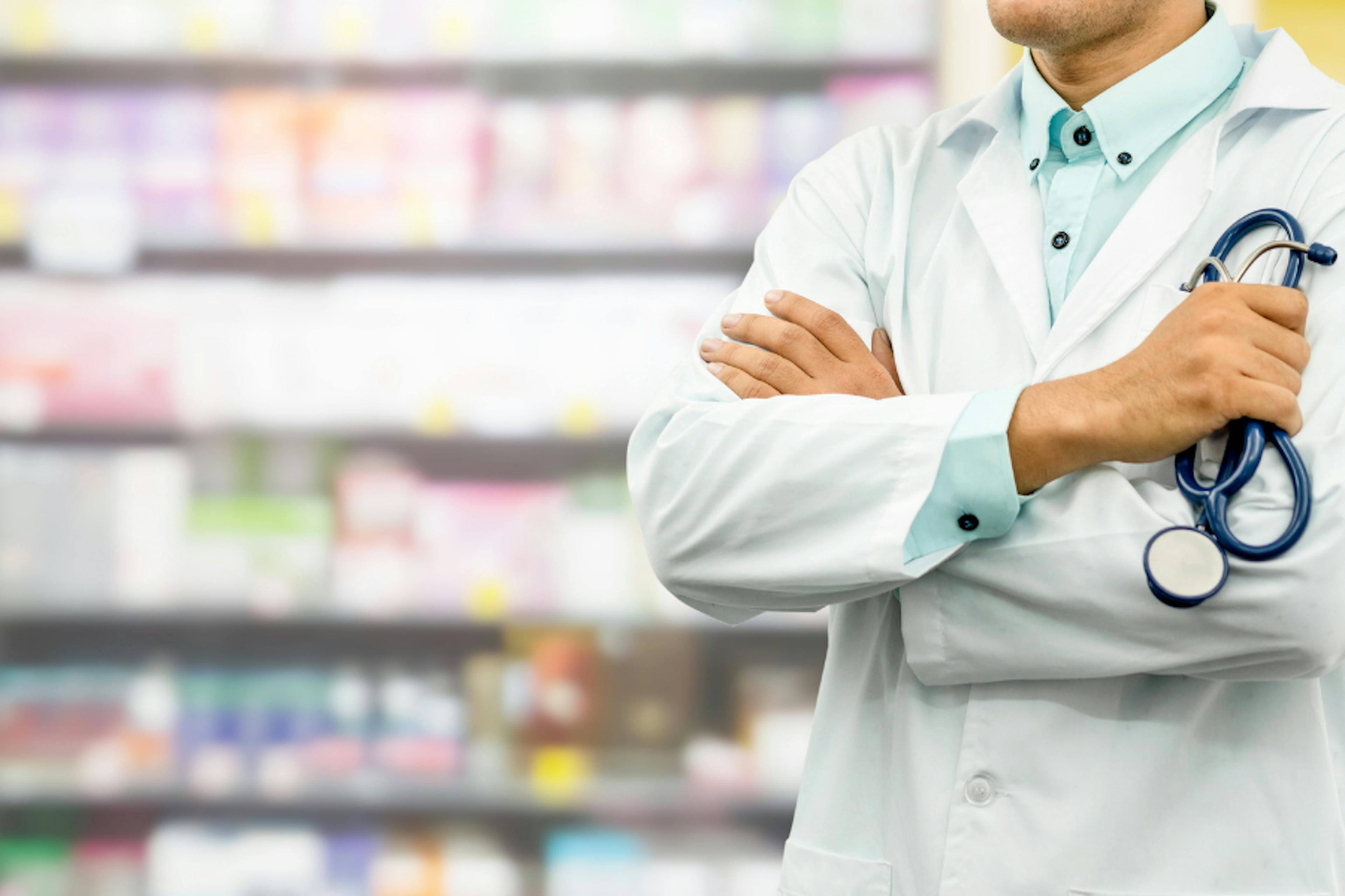 Pharmacist standing in front of shelves of medication
