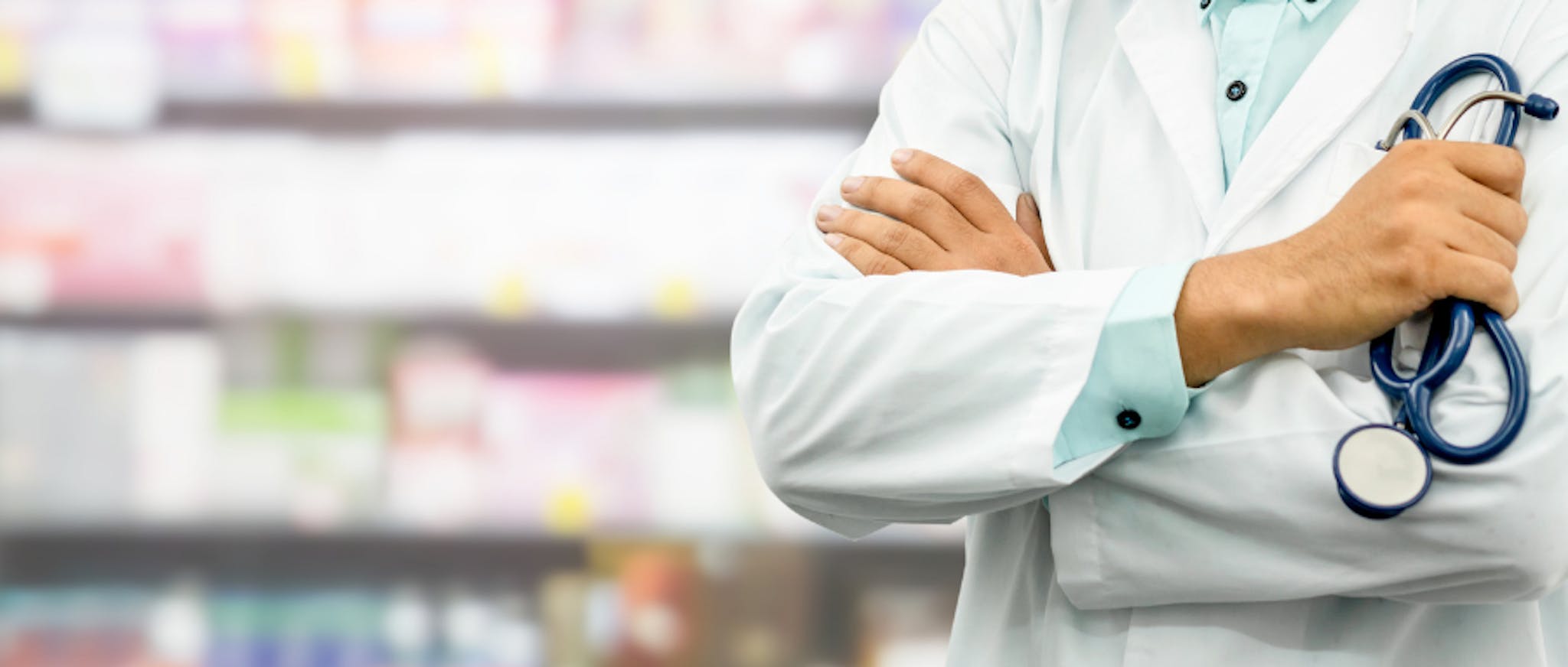 A pharmacist in front of shelves of medication