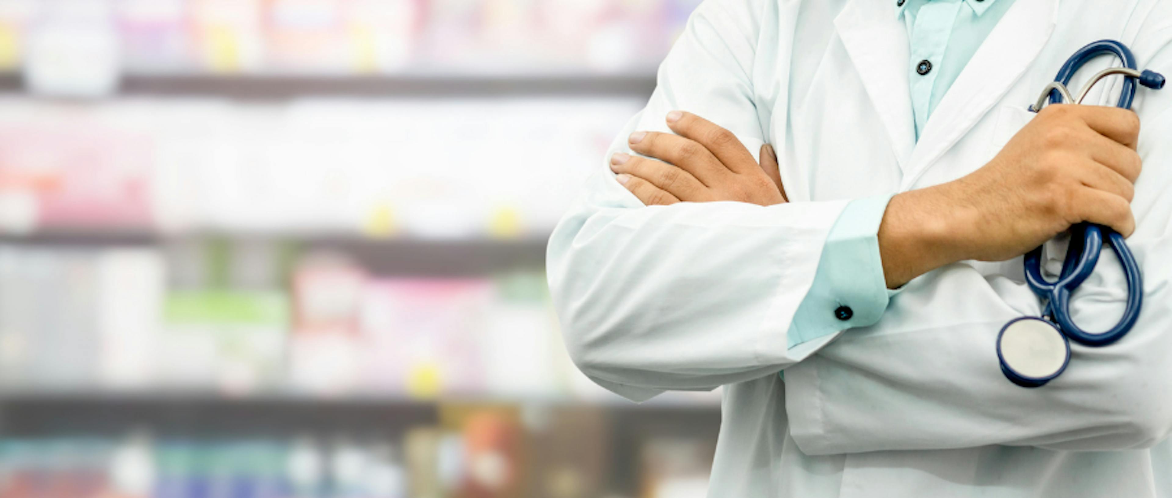 A pharmacist in front of shelves of medication