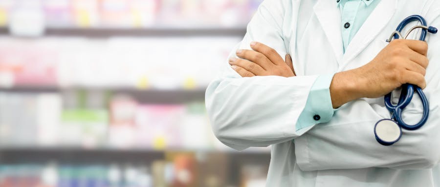 A pharmacist in front of shelves of medication