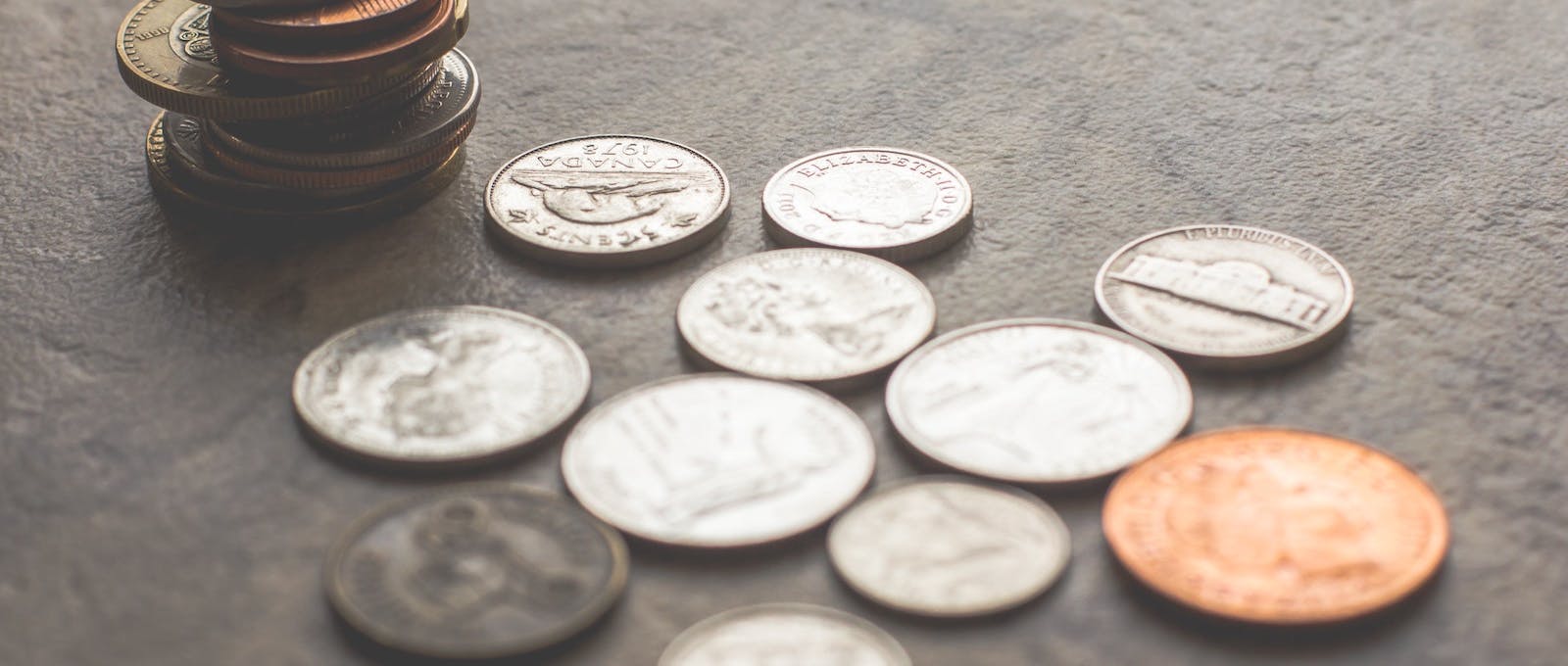 Money stacked and sitting on a grey background