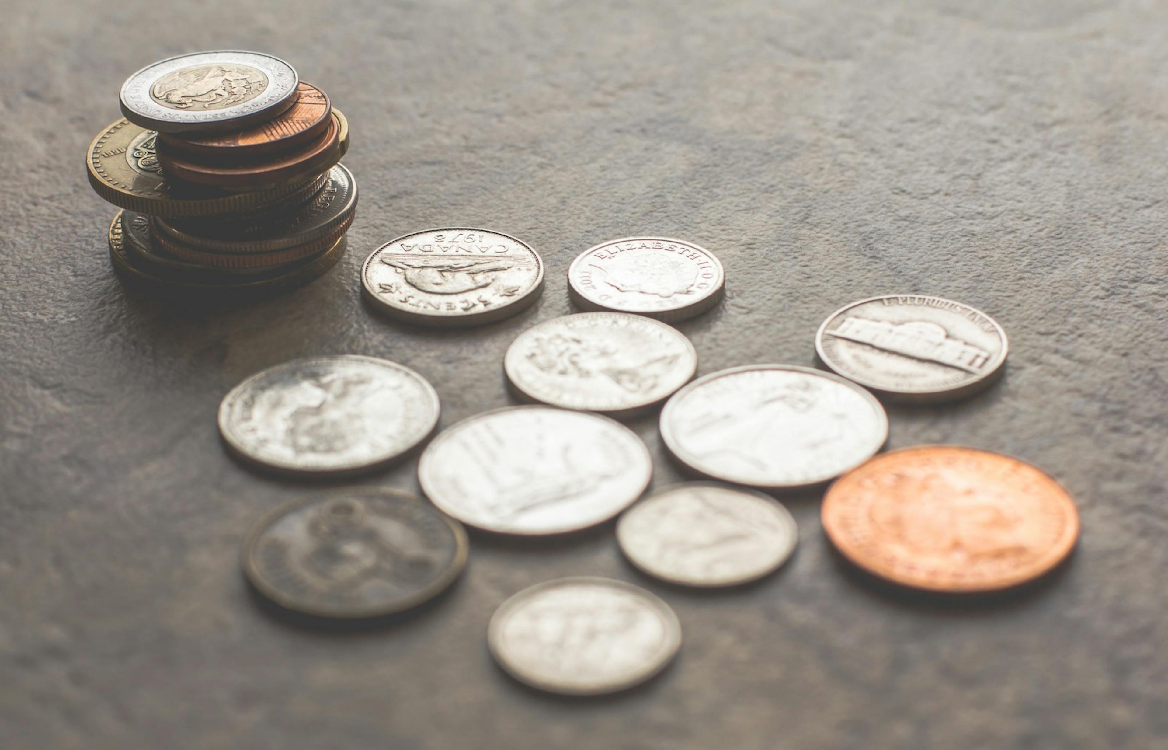 Money stacked and sitting on a grey background