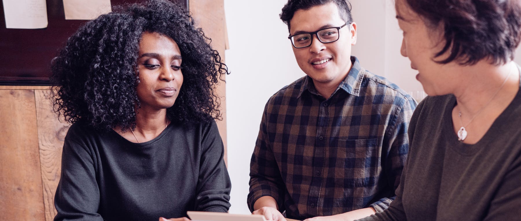 Two people receiving financial coaching from a third person.