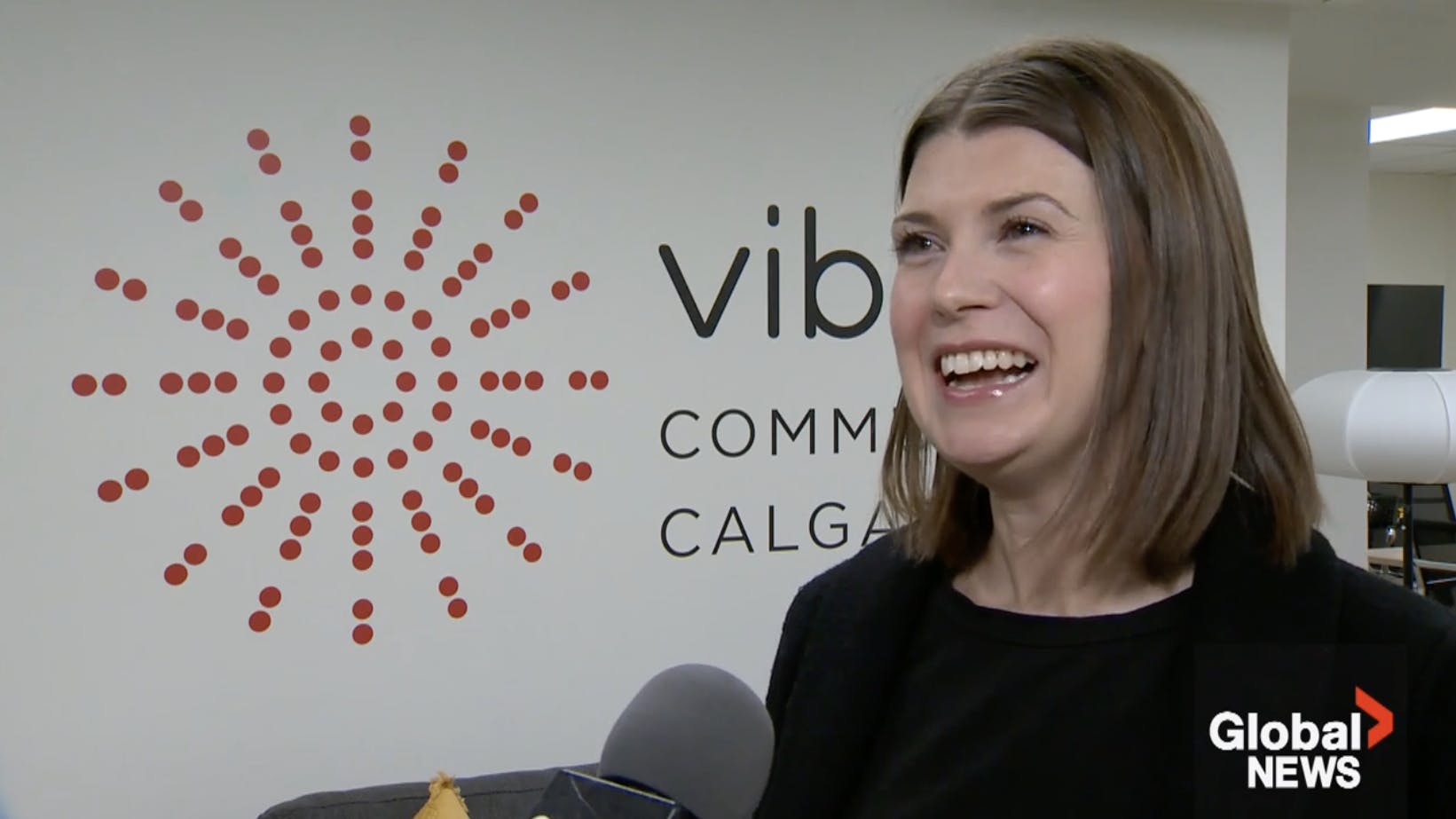 Michelle James stands in front of the Vibrant Communities Calgary logo in an interview with Global News