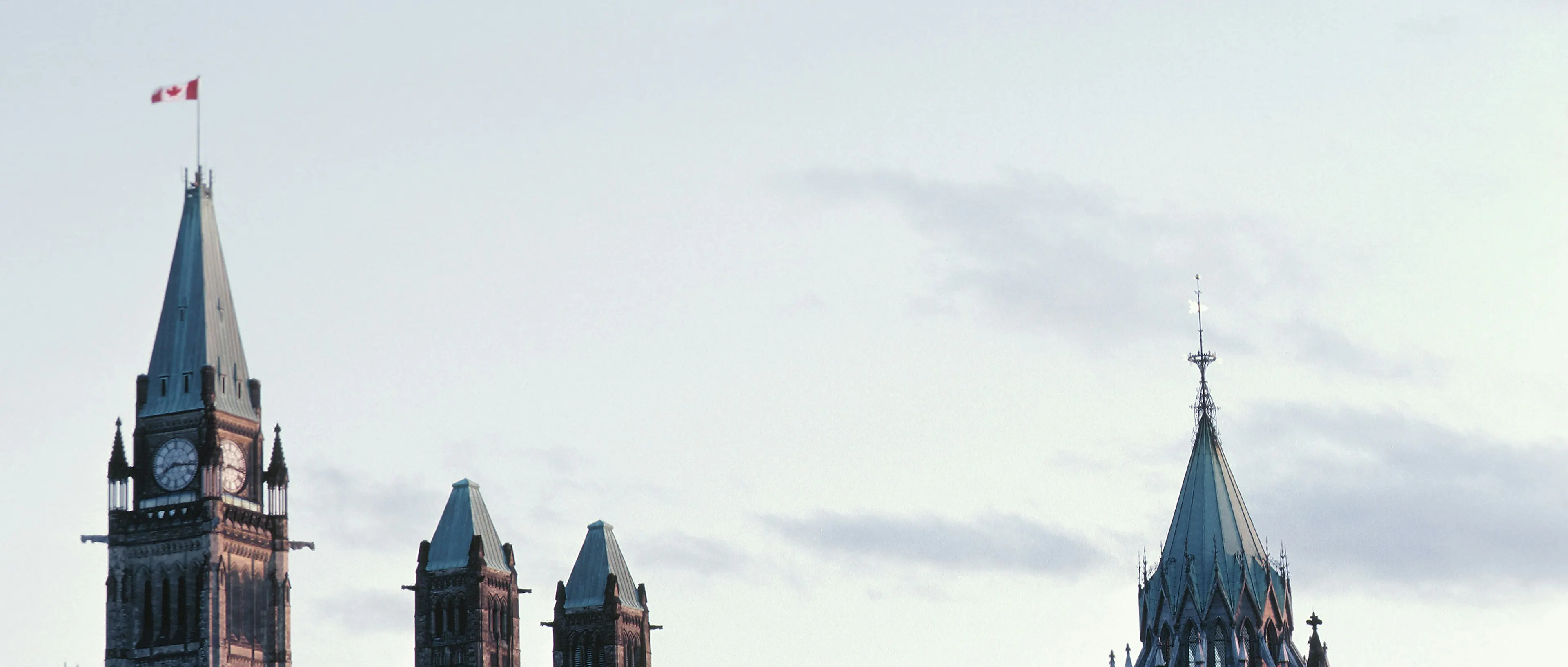 The pointed roof od the Goverment of Canada building. The sky in the background is slightly gray and clody.