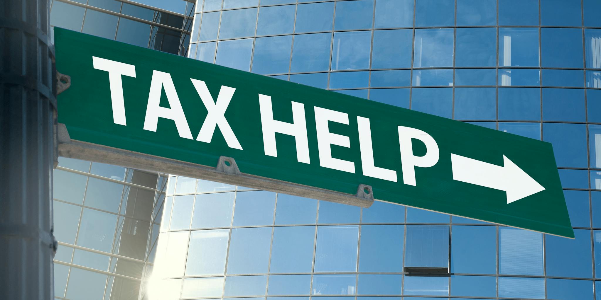 Street sign with tax help in white writing with an arrow.