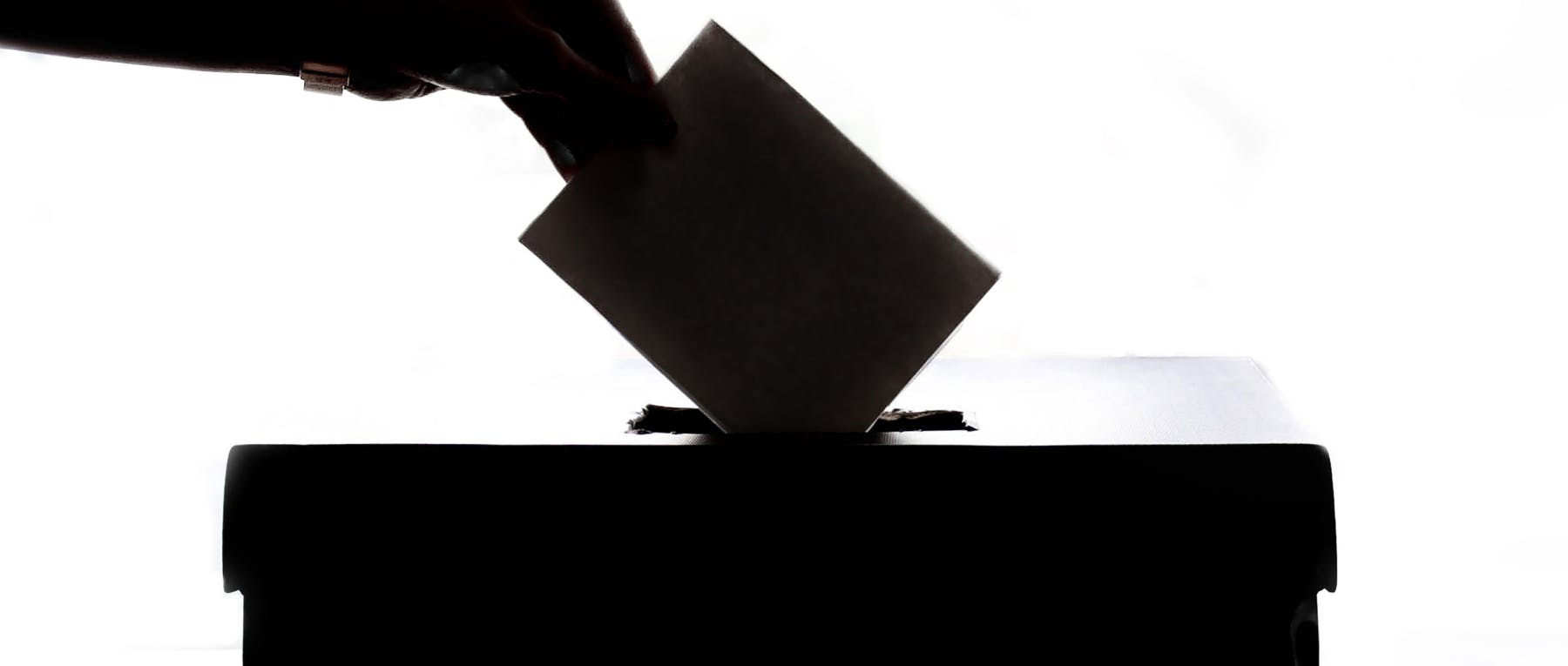 Shadow of an election ballot box and hand voting