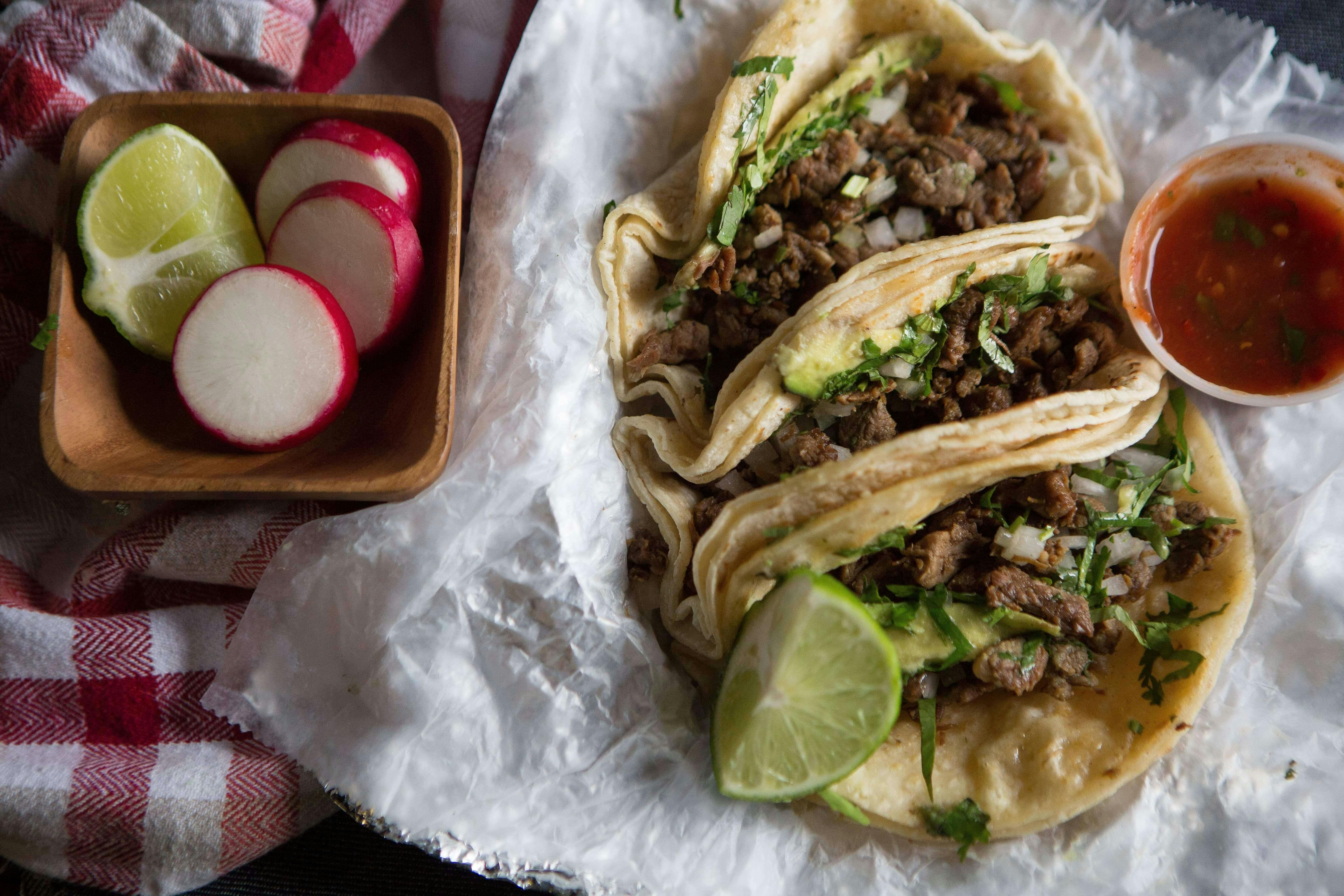 Tacos with lime, dipping sauce and radish