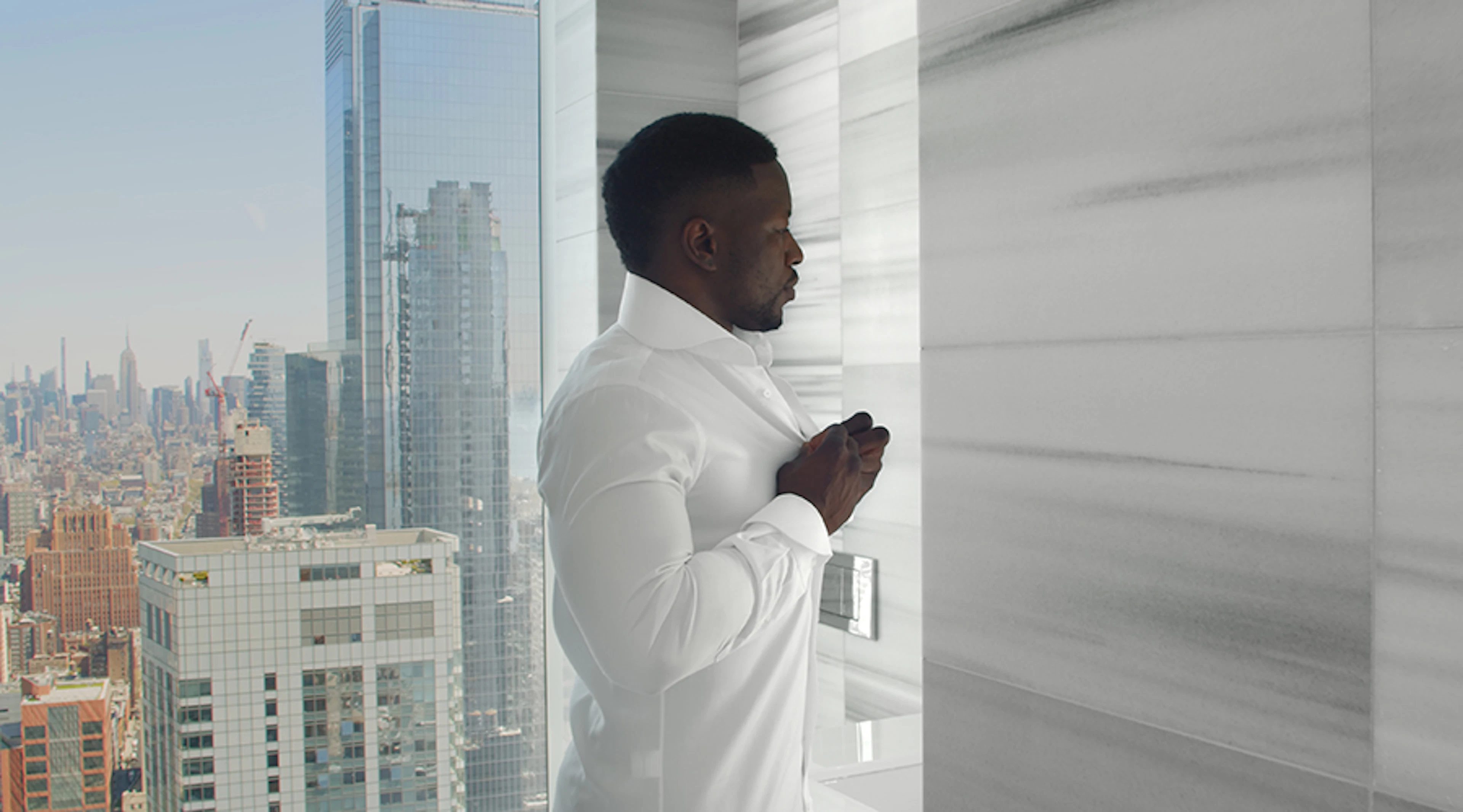 Man in mirror buttoning up shirt