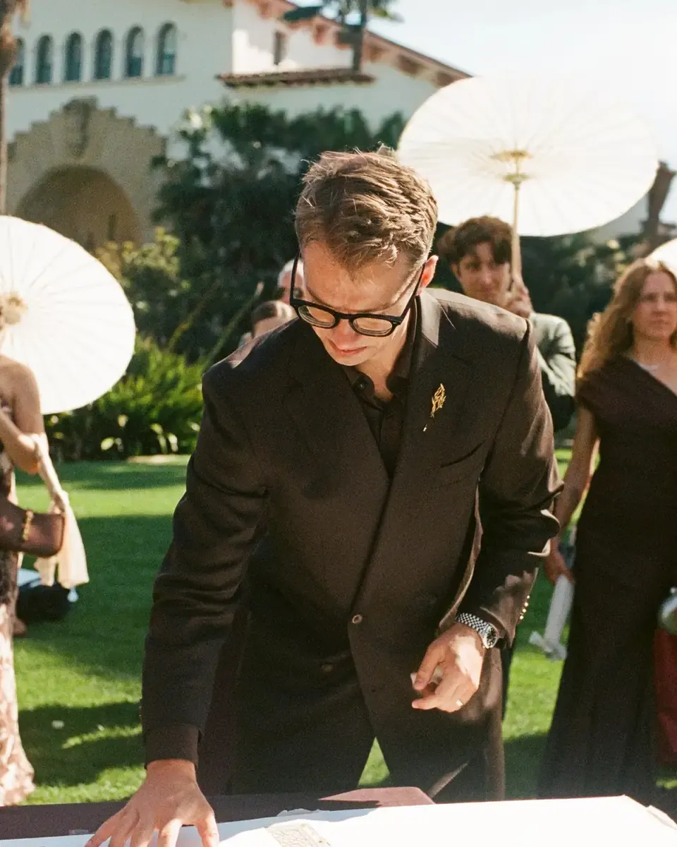 Owen in his custom Enzo Custom wedding suit, signing the marriage contract at a daytime ceremony
