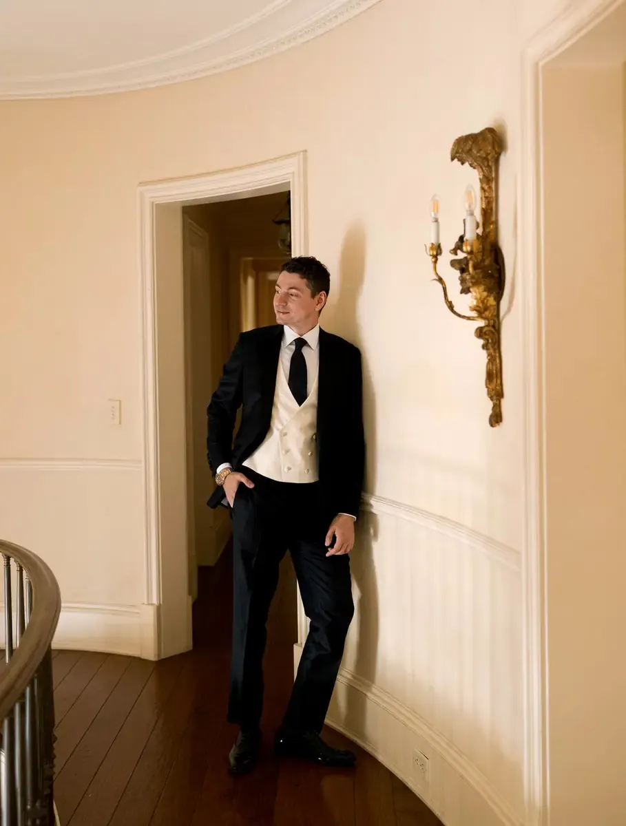 Dominic Cheli in his custom Enzo Custom navy suit leaning against the wall at Étienne Estate