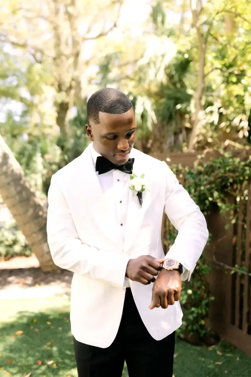 Jeremy Reaves in his custom white Enzo Custom tuxedo, adjusting his watch