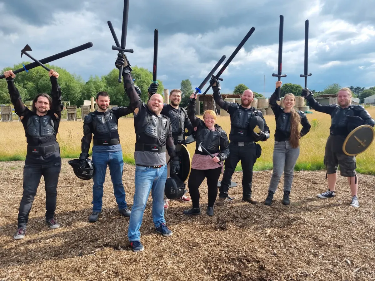 A group in padded armour raising foam swords and axes at UK Active Outdoors near Keynsham