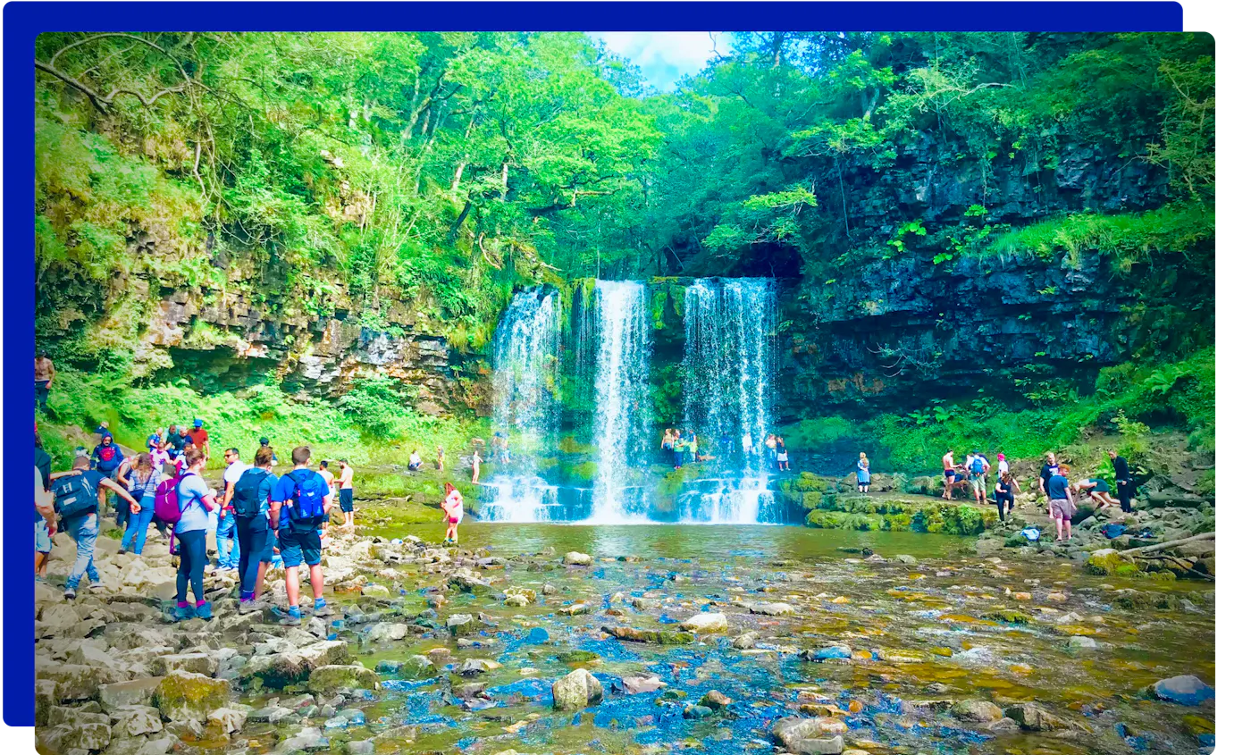 Walkers at a waterfall in the Vale of Neath at Pontneddfechan