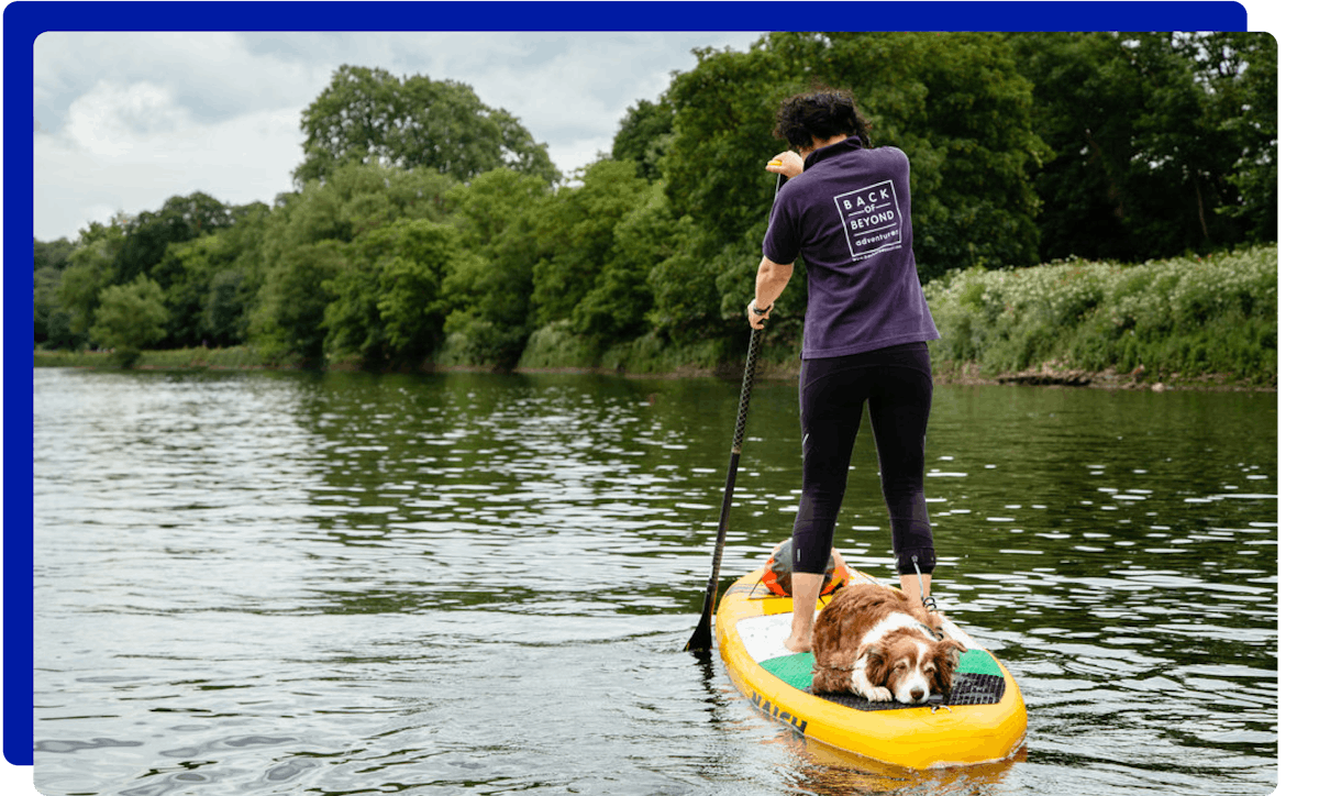 Woman paddleboarding with her dog on the River Thames