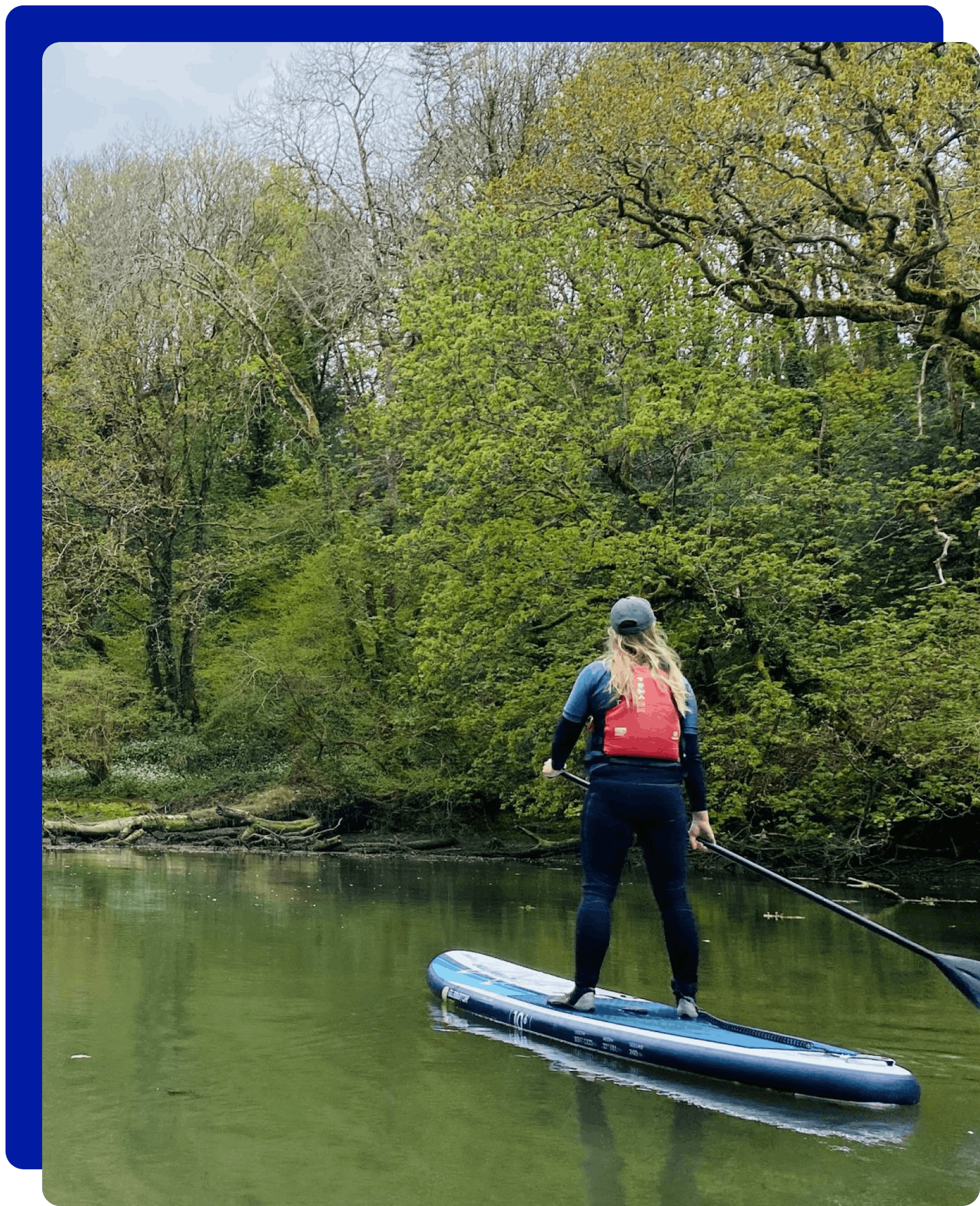 Woman standing on a paddleboarding in the Helford River, Cornwall