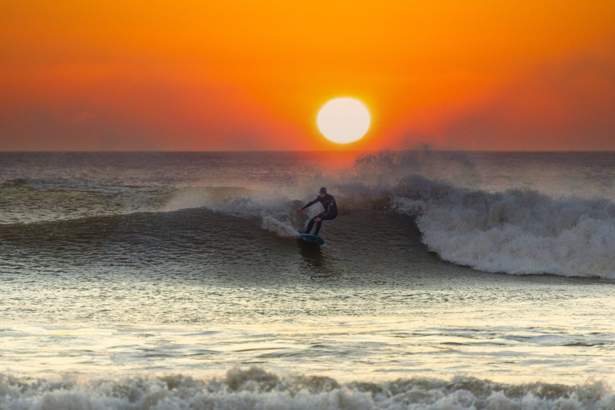 surfing as sun sets