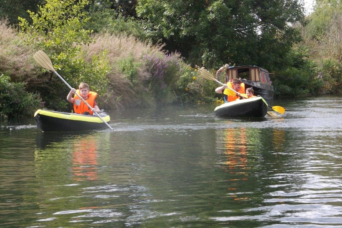 people using inflatable kayak on calm stream