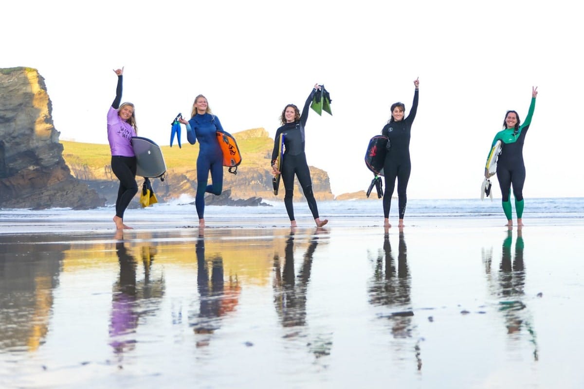 women and waves hands up on the beach