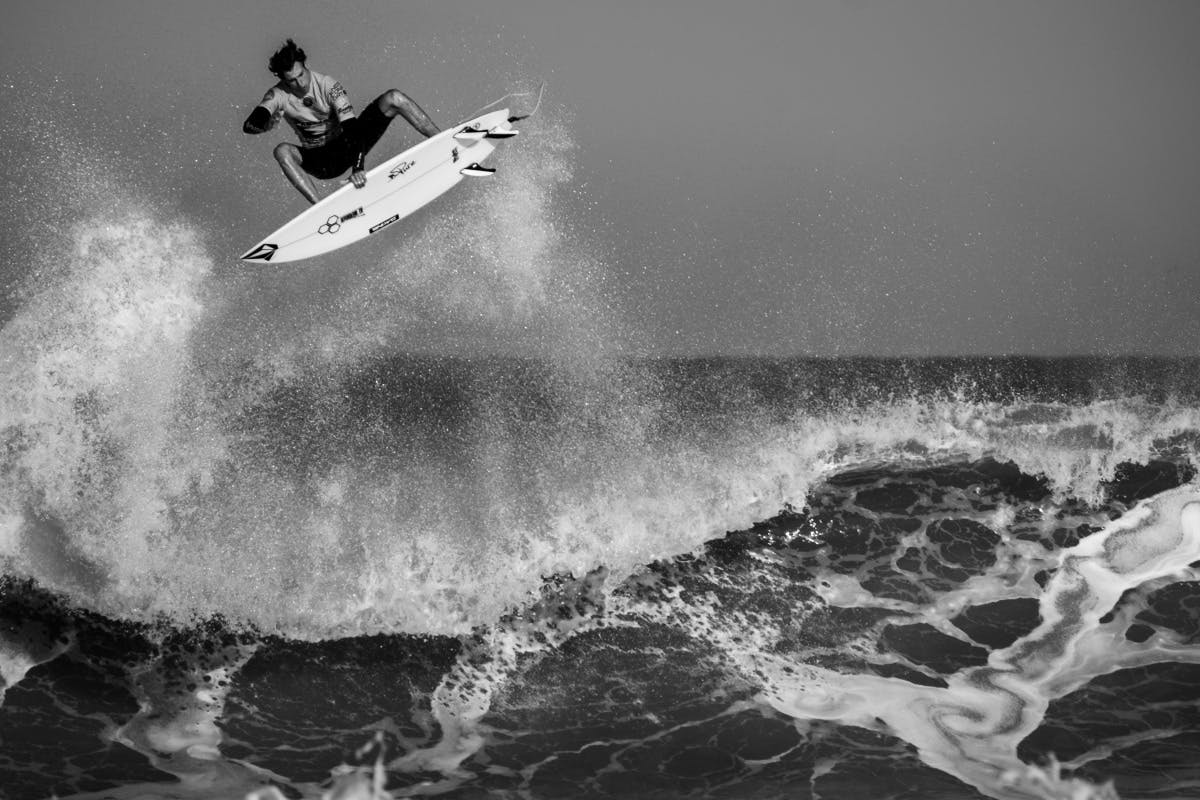 Image of surfer jumping wave