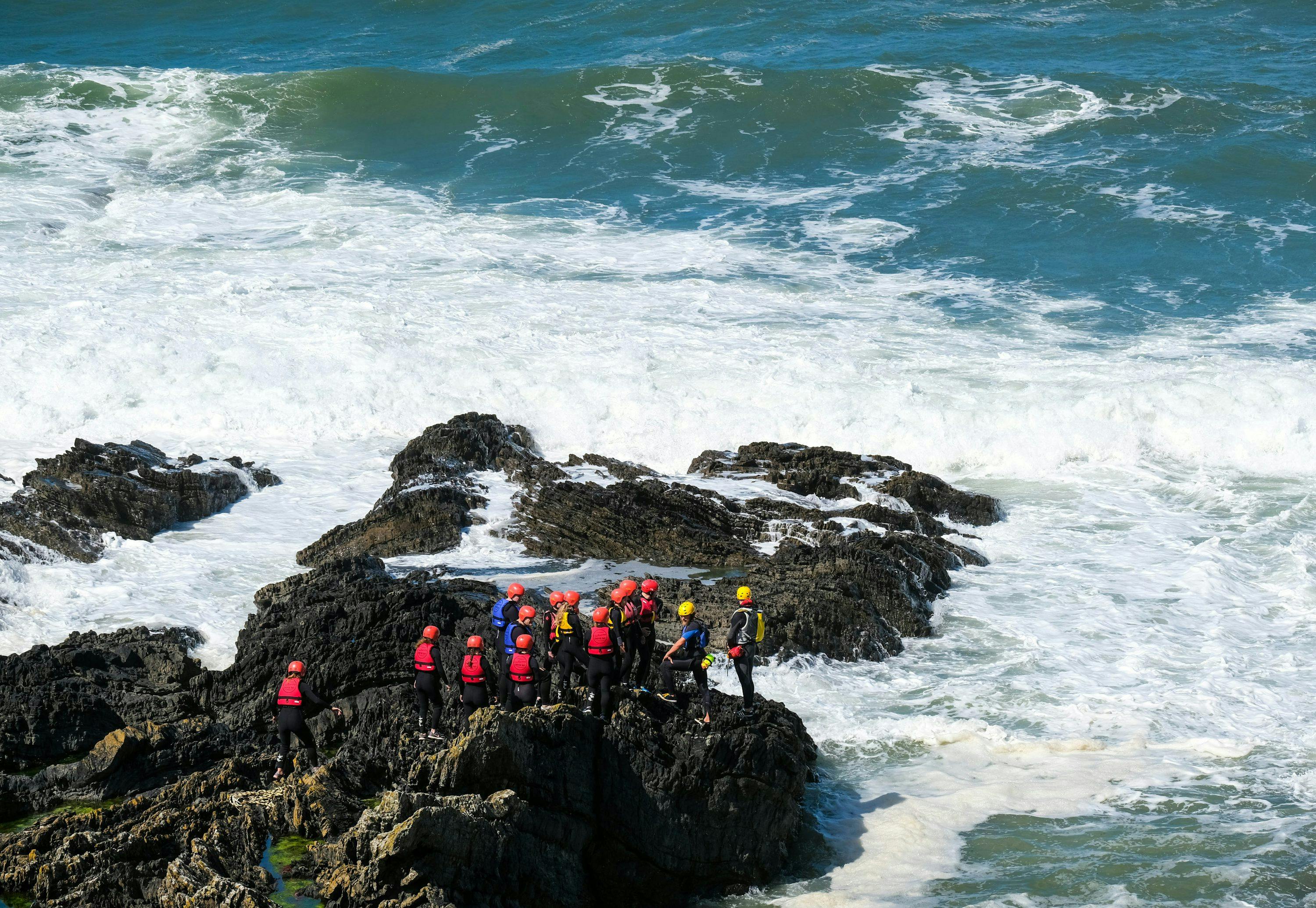 people standing on rocky shore during daytime