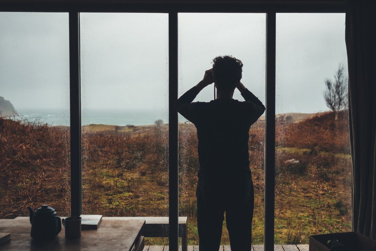 person looking out of a window with binoculars