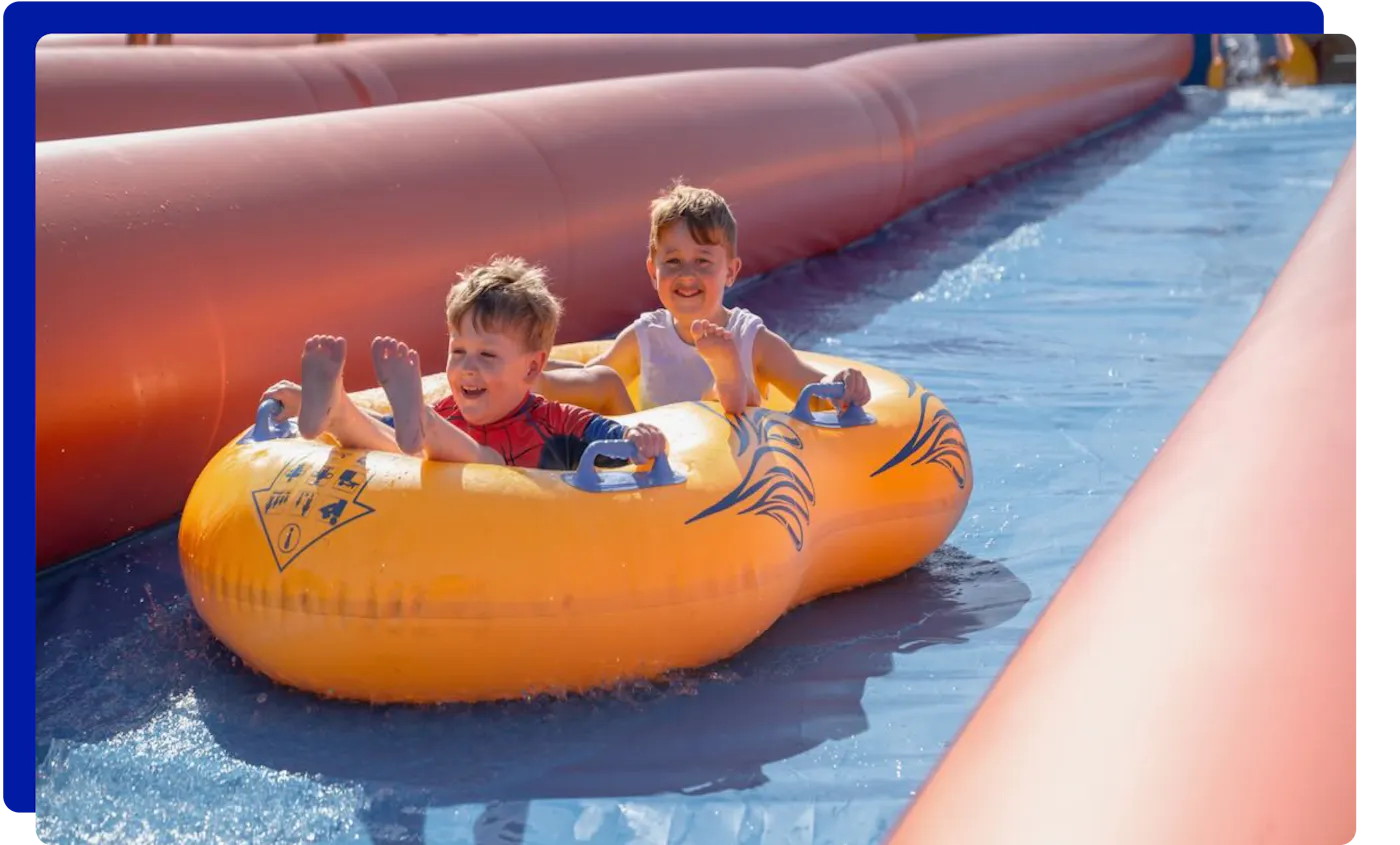 Children sliding down slip and slide in Cornwall