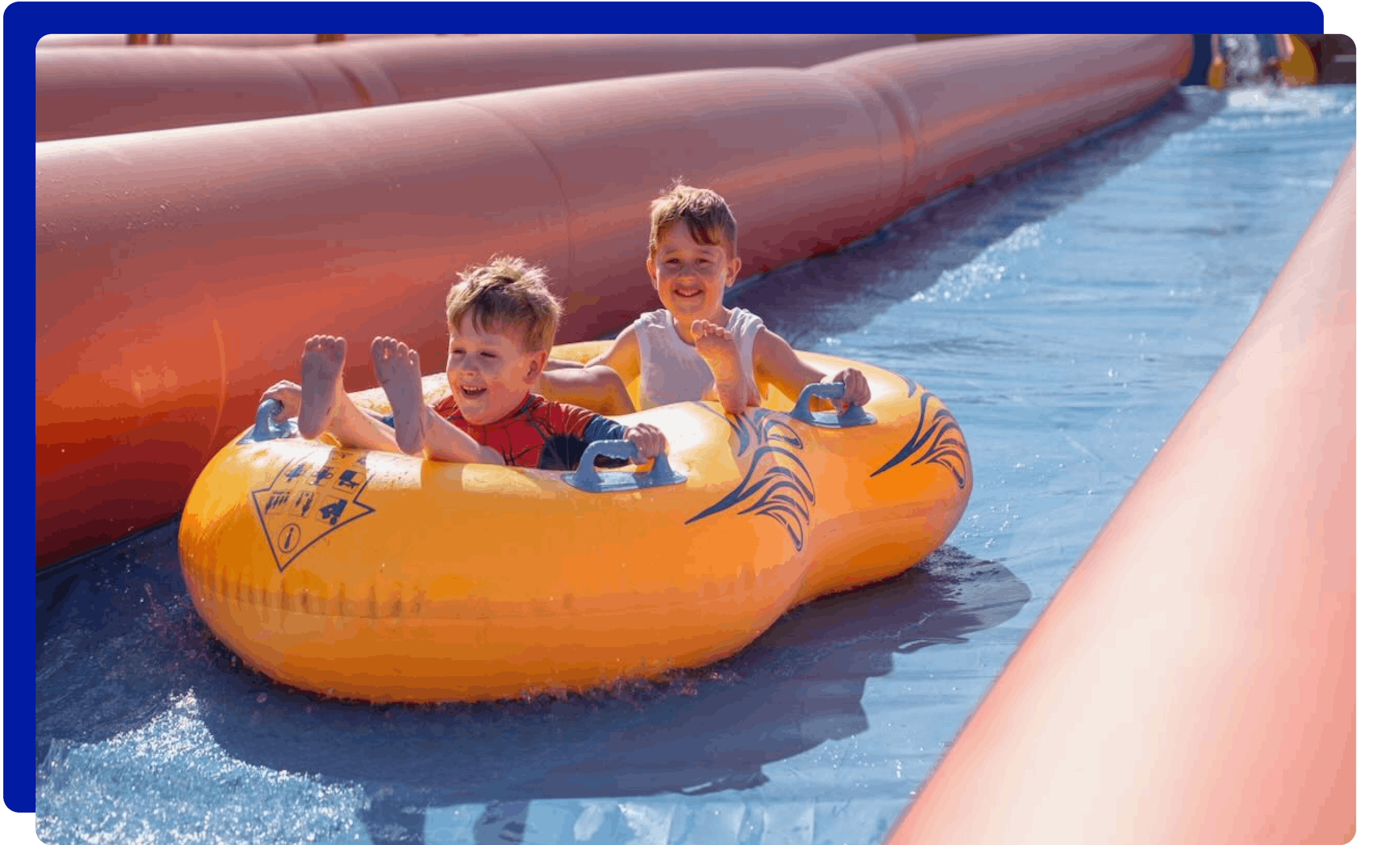 Children sliding down slip and slide in Cornwall