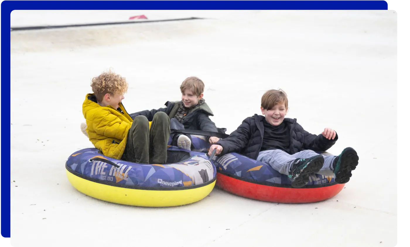 Children having fun tubing down the slopes at The Hill in Lancashire