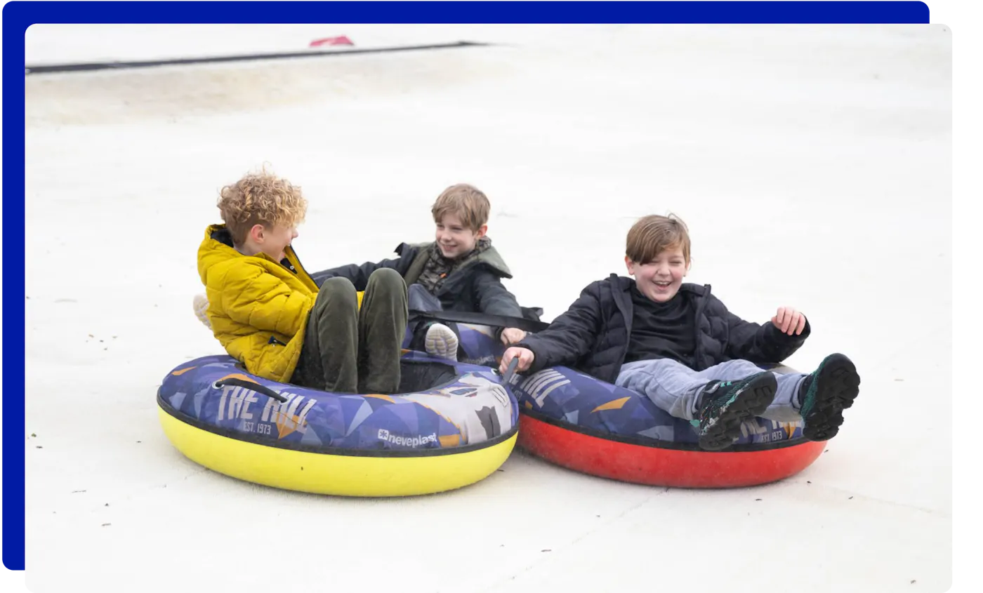Children having fun tubing down the slopes at The Hill in Lancashire