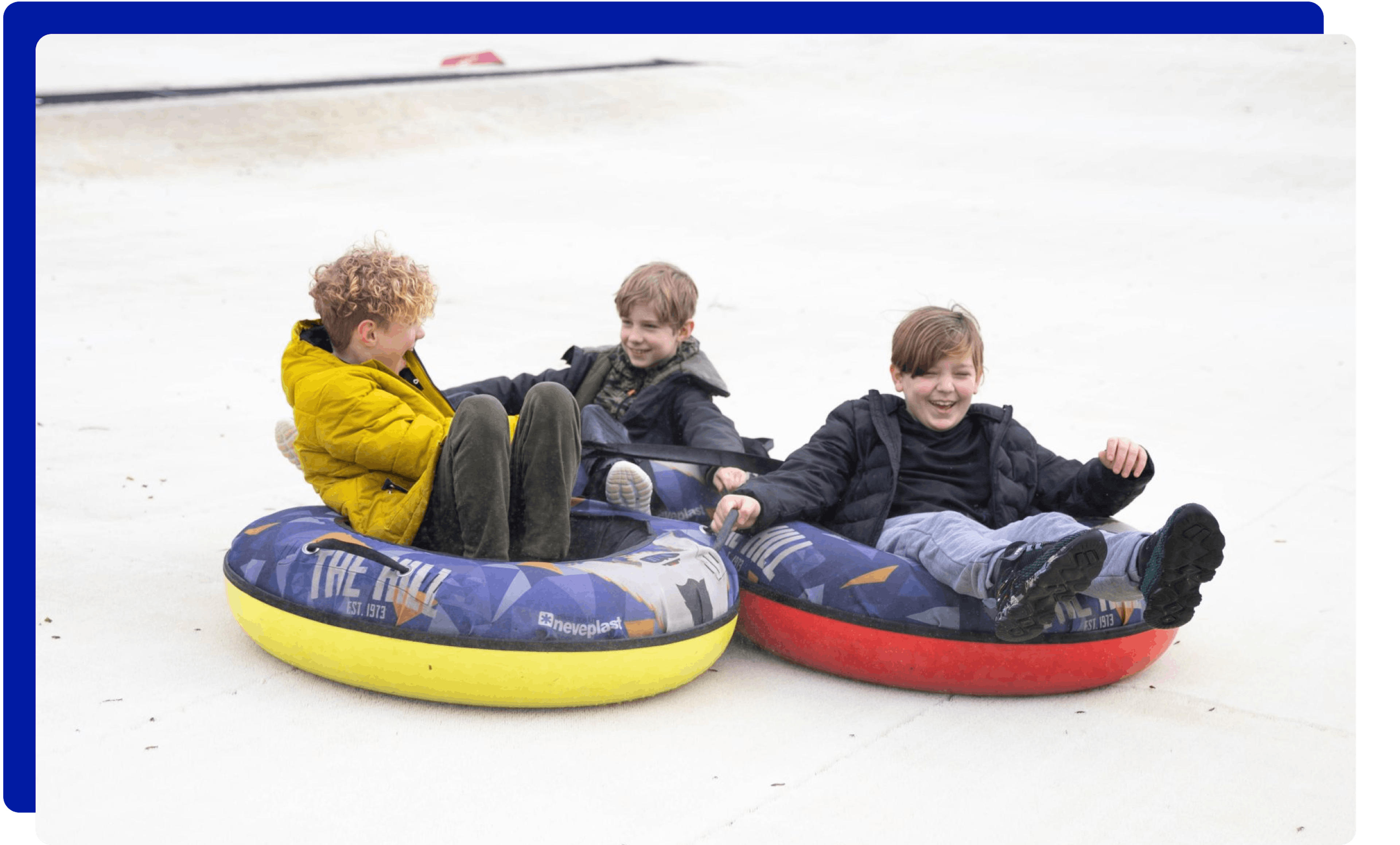 Children having fun tubing down the slopes at The Hill in Lancashire