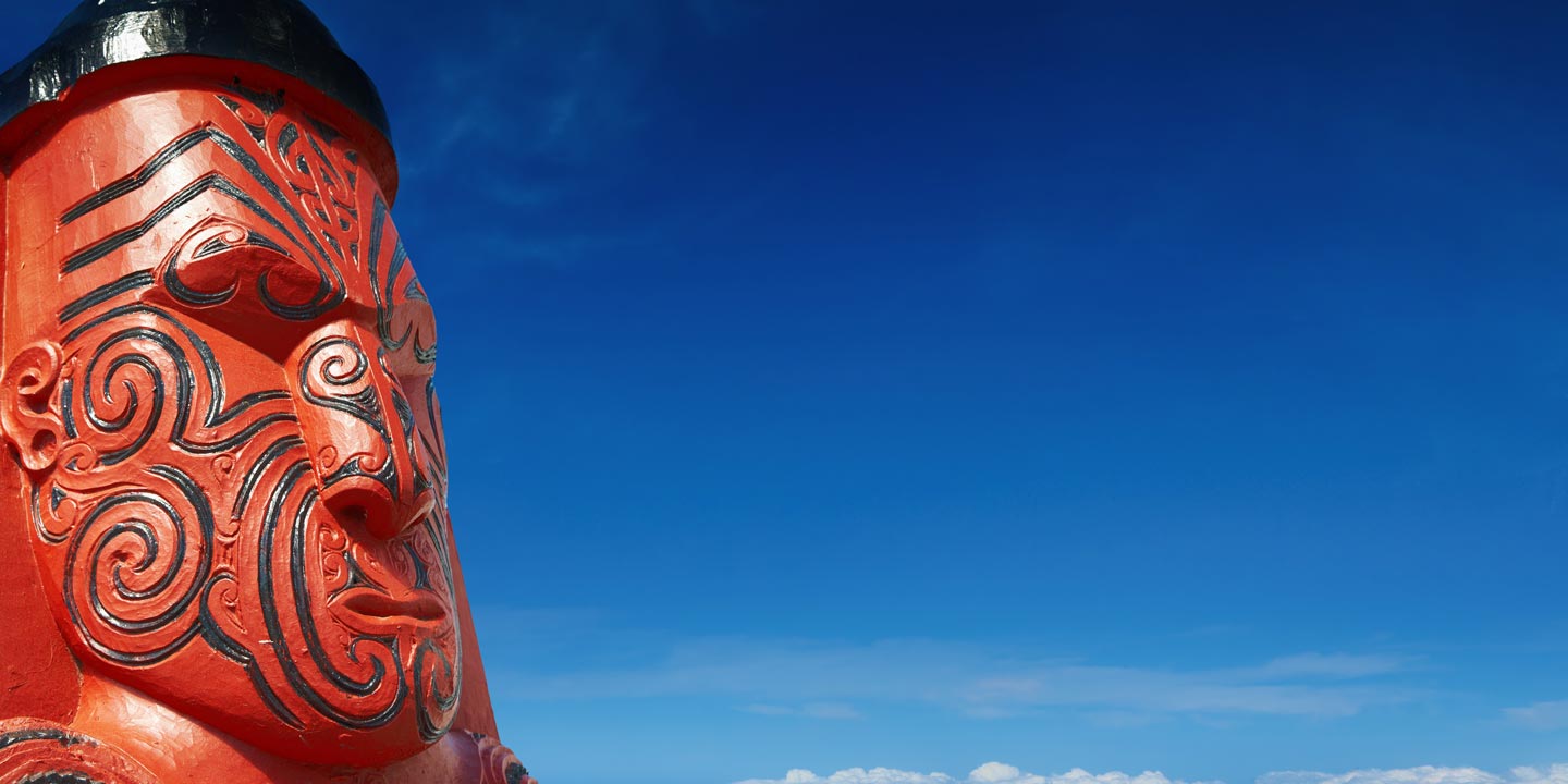 Röd och svart maoriskulptur från Nya Zeeland.