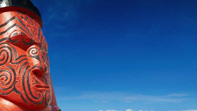 Röd och svart maoriskulptur från Nya Zeeland.
