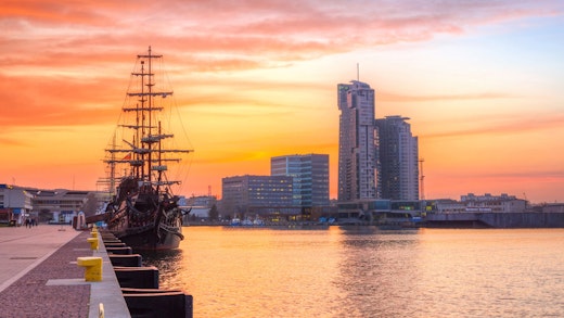 Solnedgång i Gdynia, Polen, med vackert skepp vid kajen.