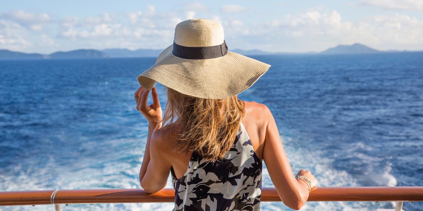 Kvinna tittar ut mot horisonten från ett kryssningsfartyg.