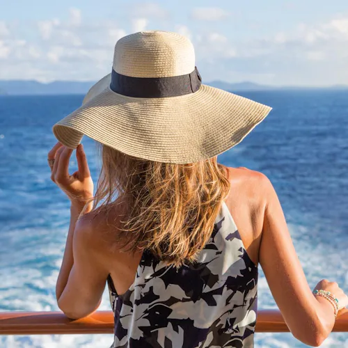 Kvinna tittar ut mot horisonten från ett kryssningsfartyg.