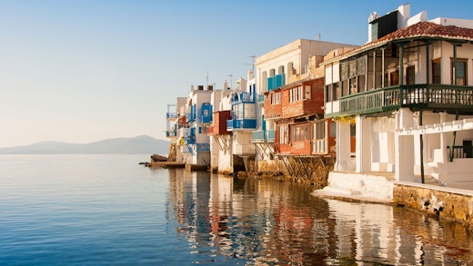 Grekiska hus precis vid vattnet, härligt badande i sol.