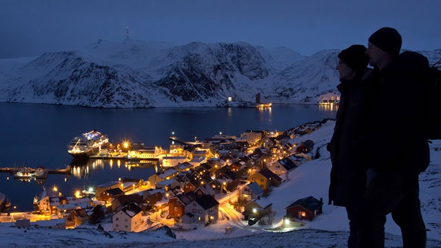 Par tittar ut över ett kvällsupplyst Honningsvåg i Norge. Foto: Ulrich Dajek/Hurtigruten