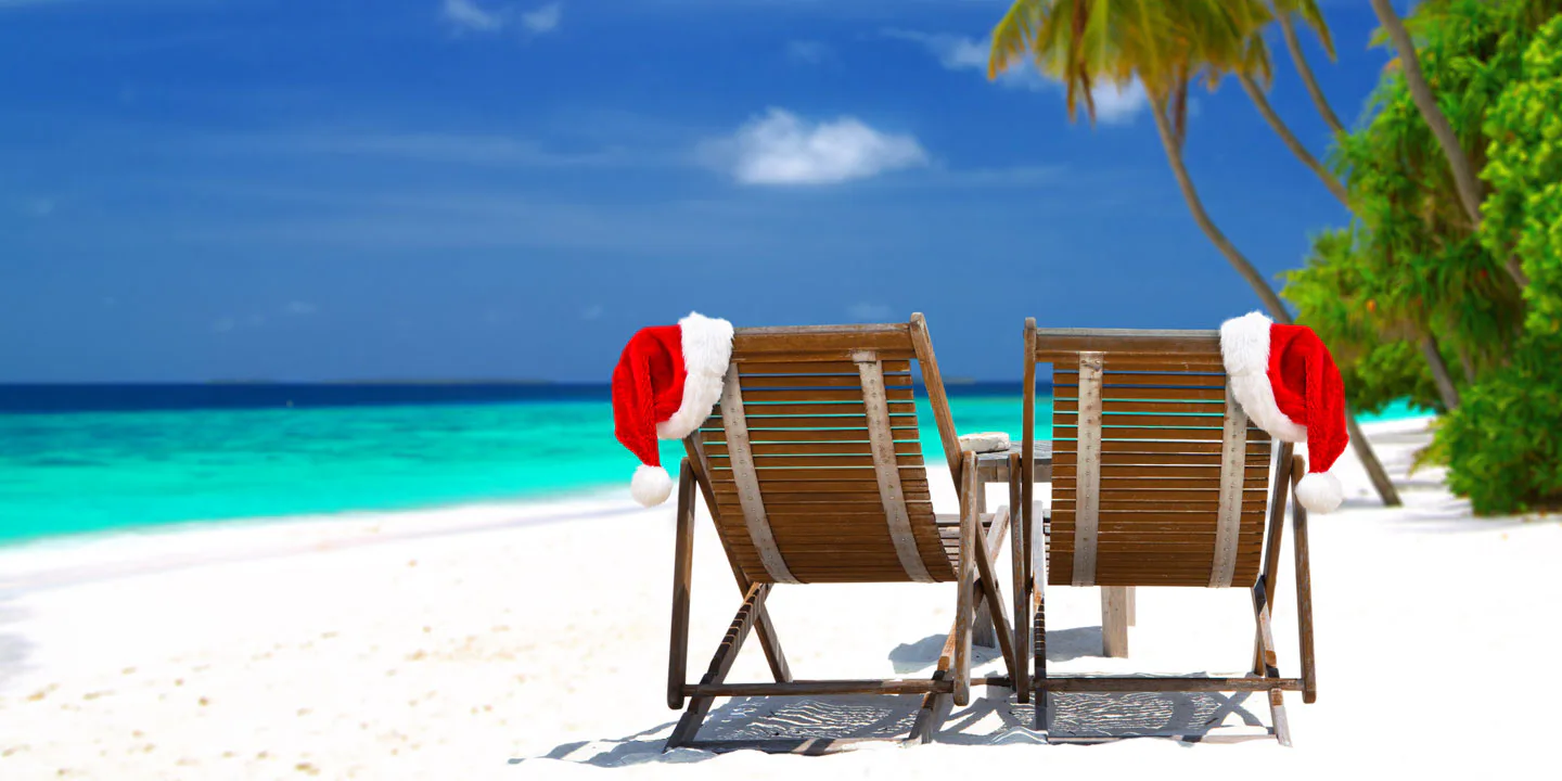 Solstolar med tomtemössor på, på en exotisk strand.